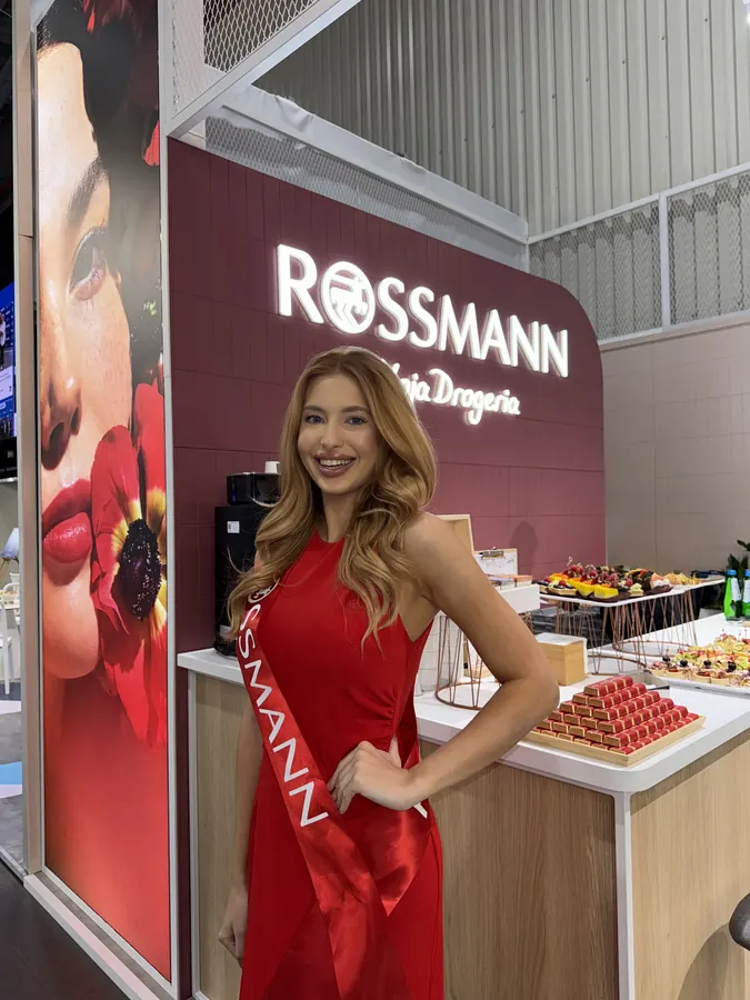 Hostessa OBSESSION w czerwonej sukni na stoisku Rossmann